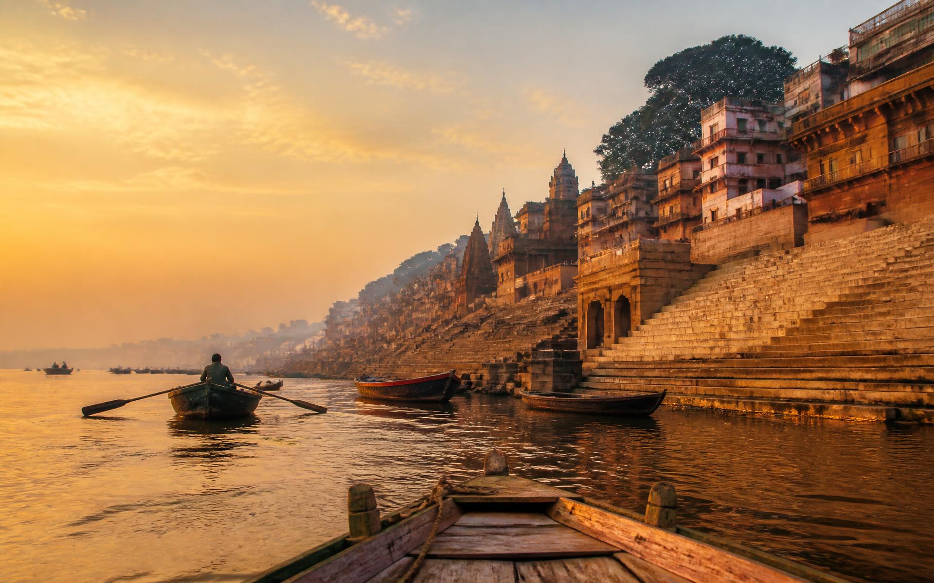 Sunrise over the ghats of Varanasi with wooden boats on the Ganges